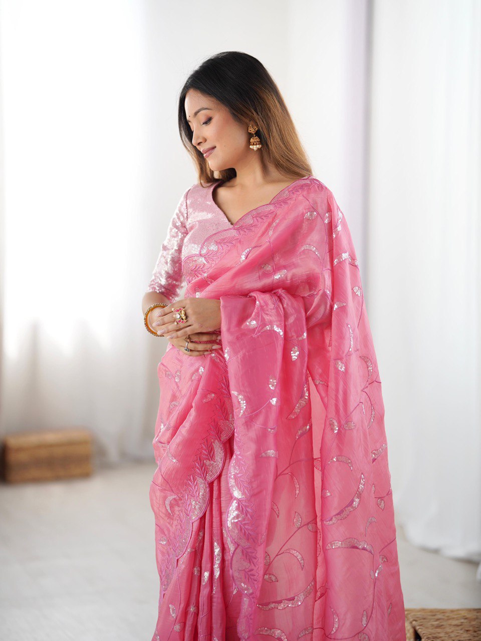 Woman wearing a pink saree with a white pattern