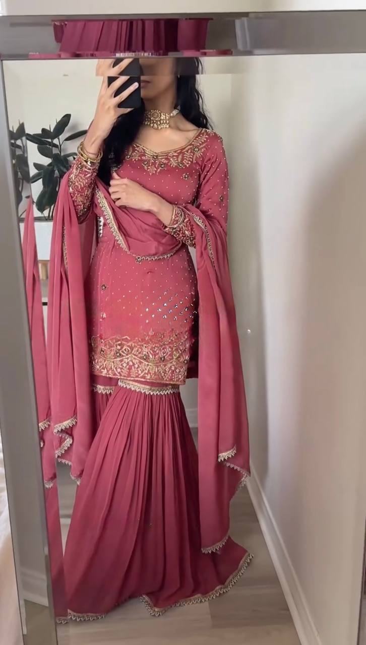 Person wearing a pink traditional outfit with gold embroidery i